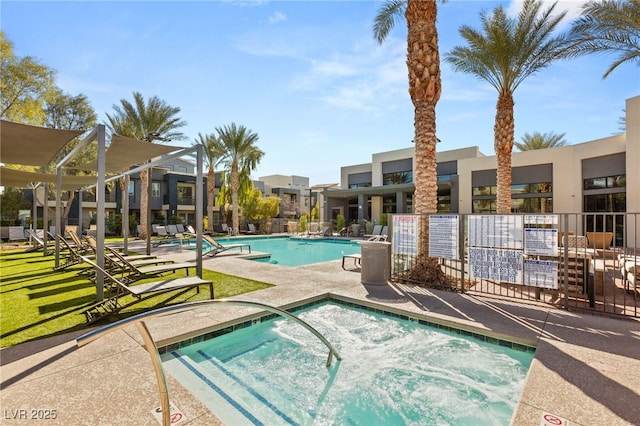 view of pool with fence and a hot tub