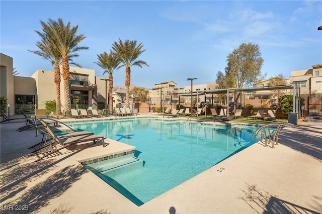 community pool featuring fence and a patio