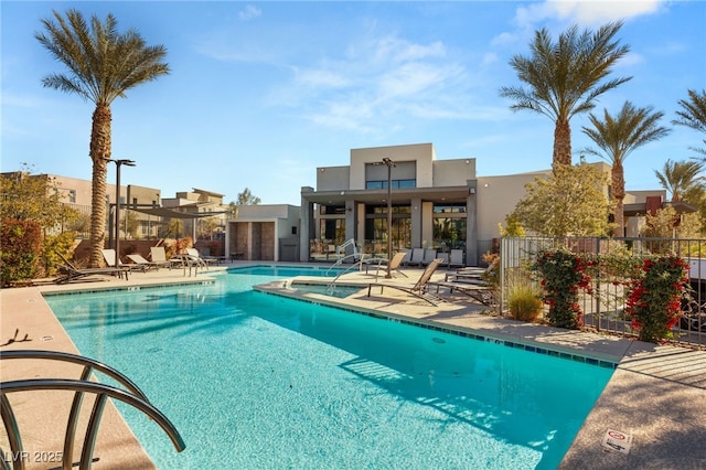 community pool with fence and a patio