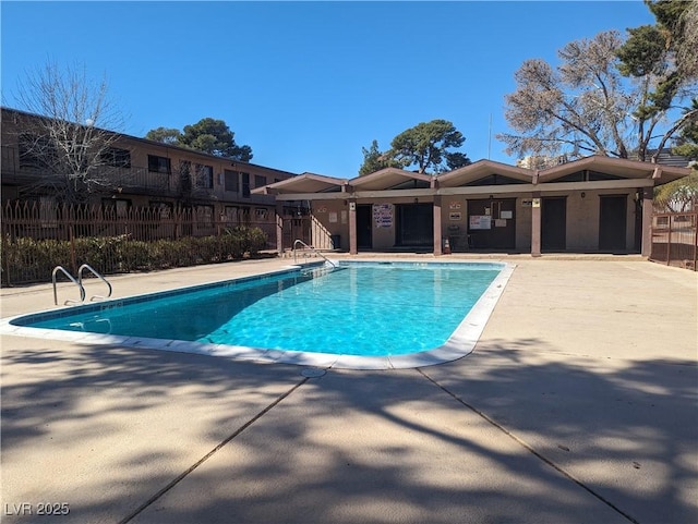 community pool with a patio and fence