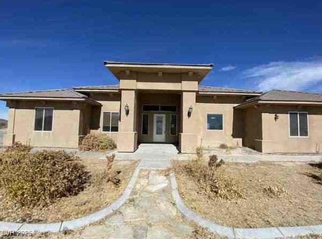 view of front of home with a patio area and stucco siding