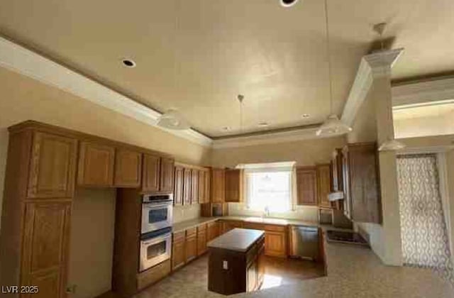 kitchen featuring brown cabinetry, crown molding, a kitchen island, and appliances with stainless steel finishes