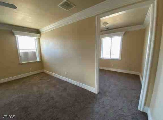 interior space with dark carpet, visible vents, and baseboards