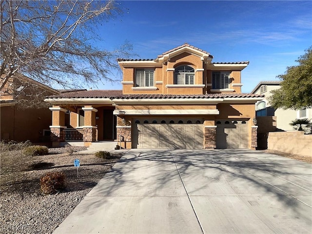 mediterranean / spanish-style house featuring a garage, stone siding, concrete driveway, a tiled roof, and stucco siding