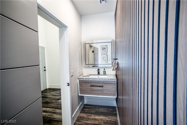 bathroom featuring baseboards, wood finished floors, and vanity