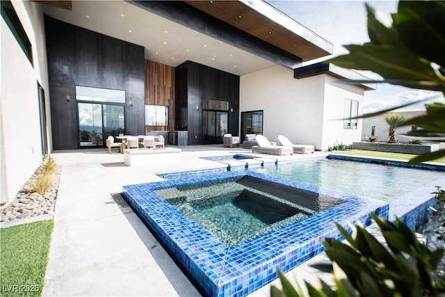 back of house with a patio area, a pool with connected hot tub, an outdoor living space, and stucco siding