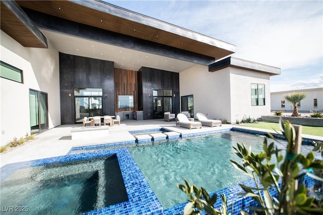 rear view of house with a patio, a pool with connected hot tub, and stucco siding