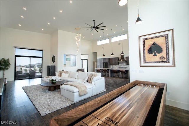 living room with recessed lighting, dark wood-style flooring, and a high ceiling