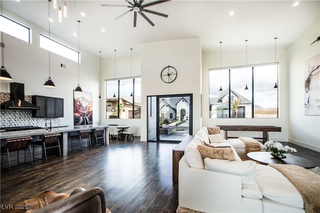 living area with dark wood-style floors, recessed lighting, plenty of natural light, and baseboards