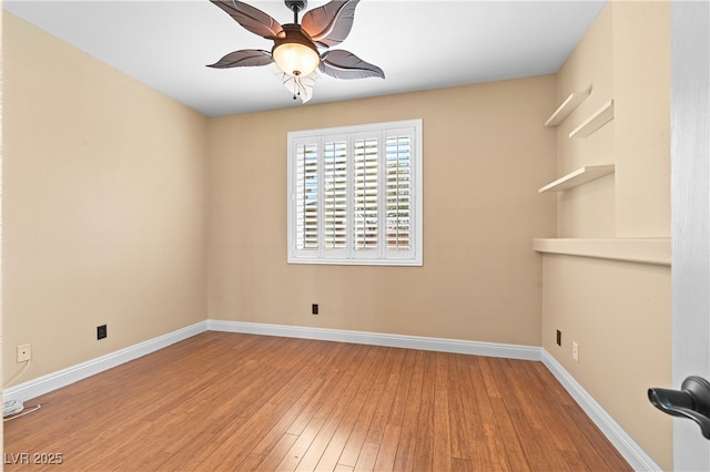 spare room with a ceiling fan, baseboards, and wood finished floors