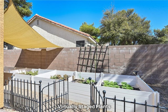 view of side of property with a tiled roof, a garden, fence private yard, and stucco siding