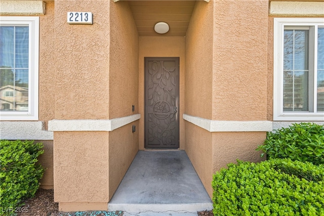 view of exterior entry featuring stucco siding