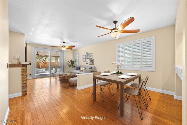 dining room featuring baseboards, light wood-style flooring, and a ceiling fan