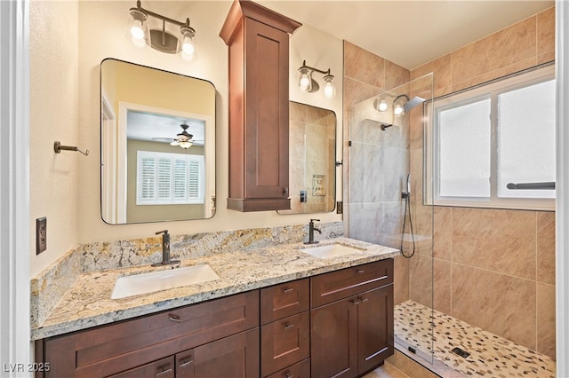 full bath with a tile shower, plenty of natural light, and a sink