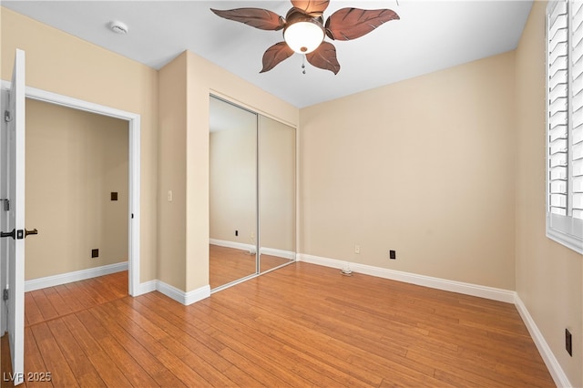 unfurnished bedroom with light wood finished floors, ceiling fan, baseboards, and a closet