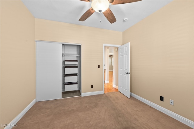 unfurnished bedroom with a closet, baseboards, carpet, and a ceiling fan