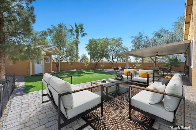 view of patio / terrace with an outbuilding, an outdoor living space, and a fenced backyard