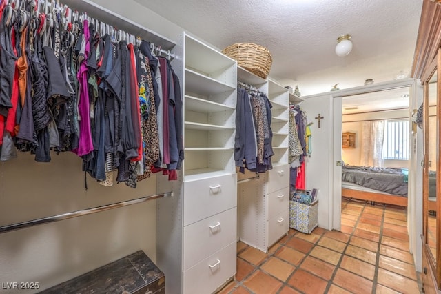 walk in closet with light tile patterned flooring