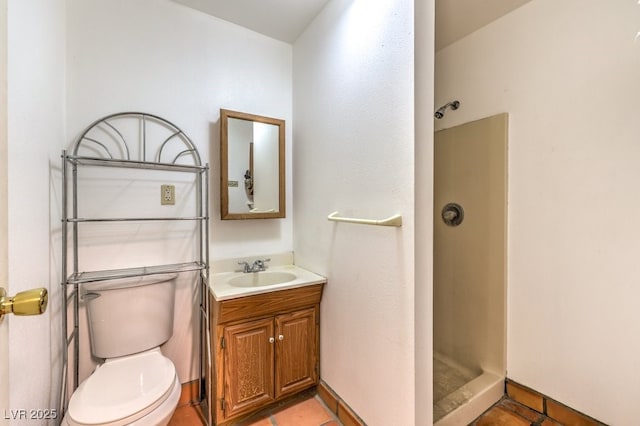 bathroom with baseboards, a shower stall, toilet, and vanity