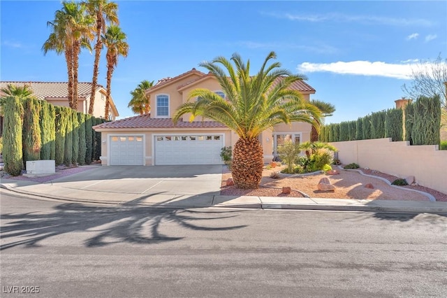 mediterranean / spanish-style house with driveway, a garage, a tile roof, fence, and stucco siding