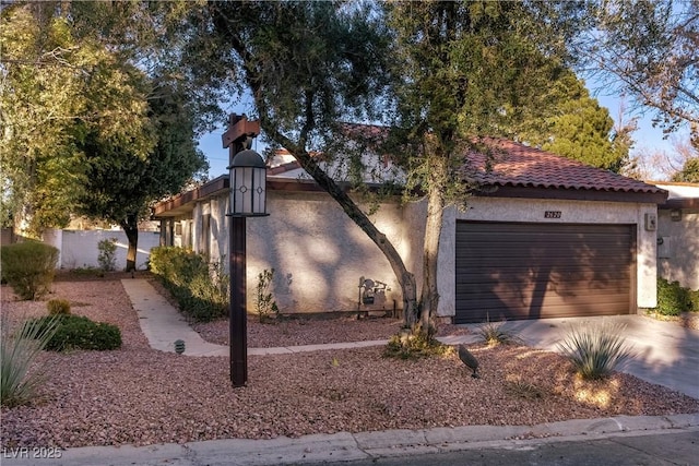 view of front of property with driveway, an attached garage, and stucco siding