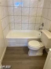 full bathroom with toilet, bathing tub / shower combination, wood finished floors, and vanity