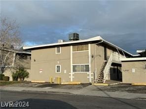 view of property featuring stairs and central AC unit