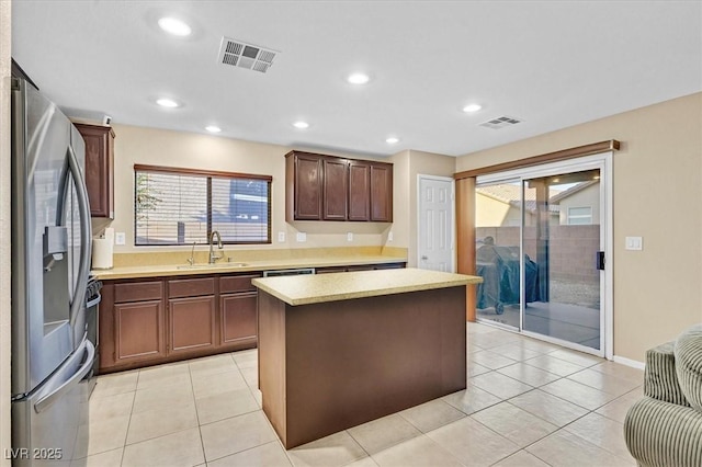 kitchen with recessed lighting, a sink, visible vents, stainless steel fridge with ice dispenser, and a center island