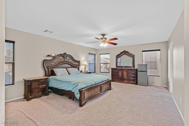 bedroom with light carpet, baseboards, visible vents, and freestanding refrigerator