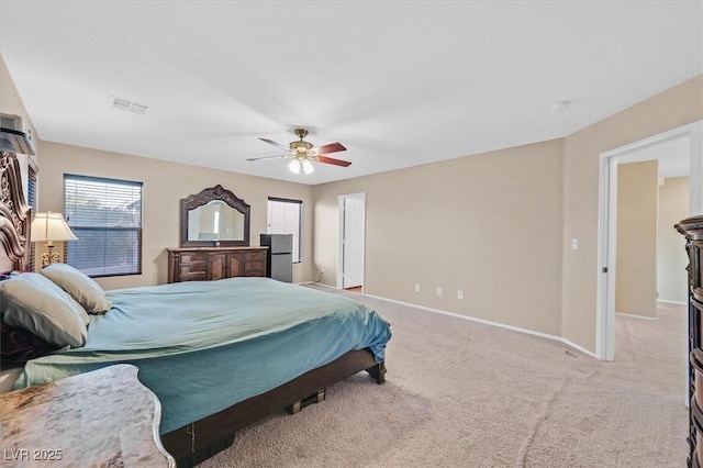 bedroom featuring ceiling fan, visible vents, baseboards, and light colored carpet