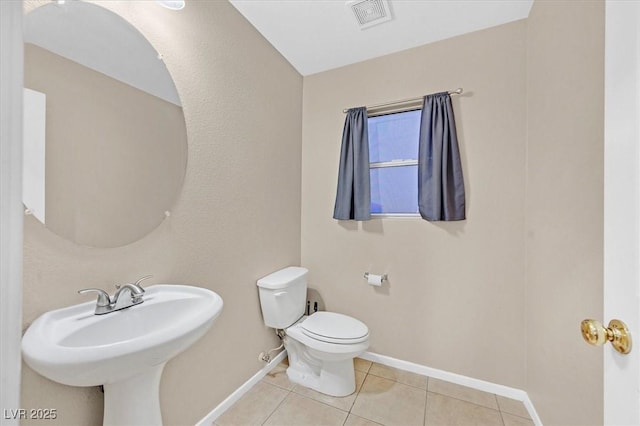 bathroom with visible vents, toilet, a sink, tile patterned flooring, and baseboards