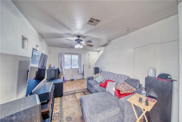 living room featuring visible vents, a ceiling fan, and wood finished floors