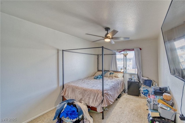 carpeted bedroom with baseboards, a textured ceiling, ceiling fan, and a textured wall