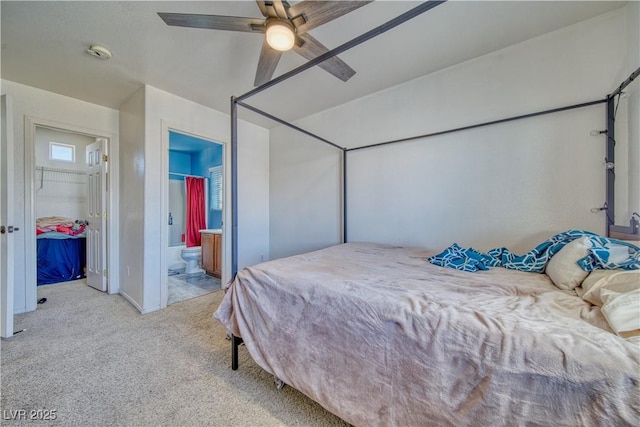 carpeted bedroom featuring ensuite bath and a ceiling fan