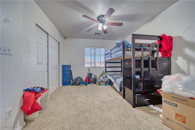 bedroom featuring visible vents, carpet, and a textured wall