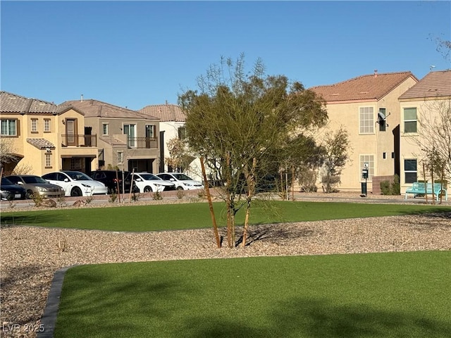 view of community with a residential view, uncovered parking, and a yard