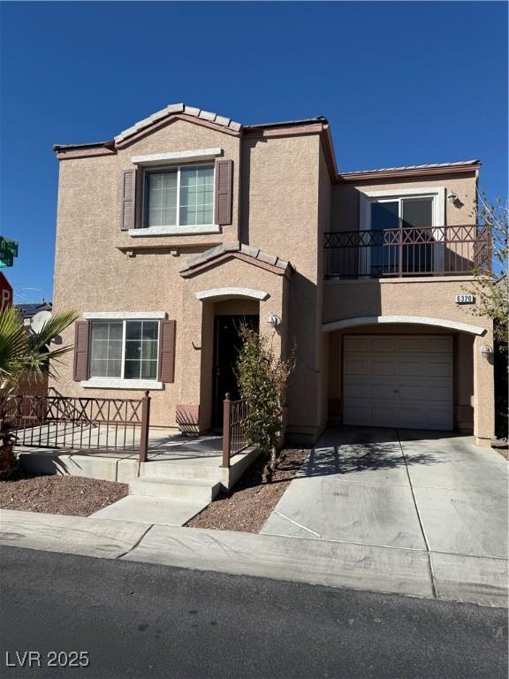 view of front of home with a garage, driveway, a balcony, and stucco siding