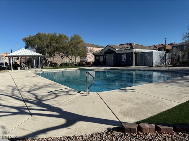 pool featuring fence, a patio, and a gazebo