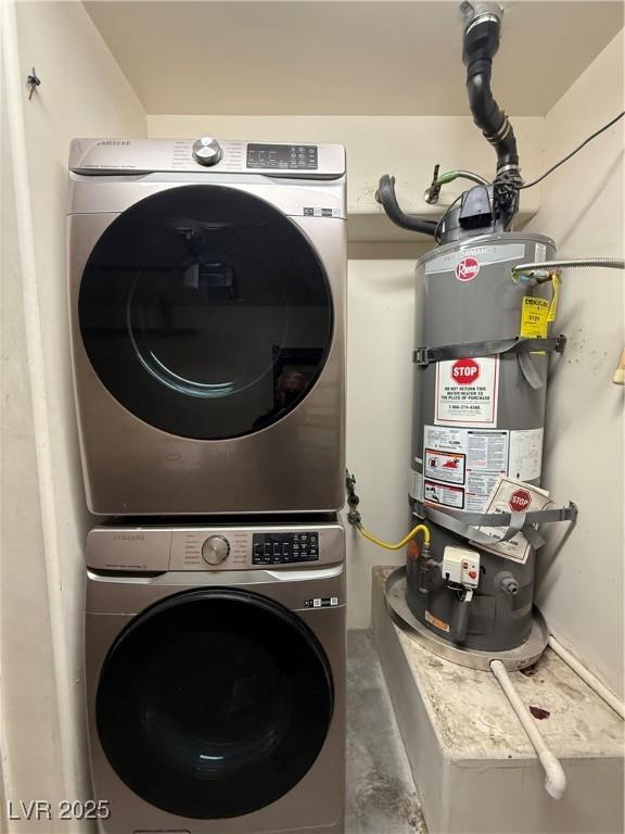 laundry area featuring laundry area, water heater, and stacked washing maching and dryer