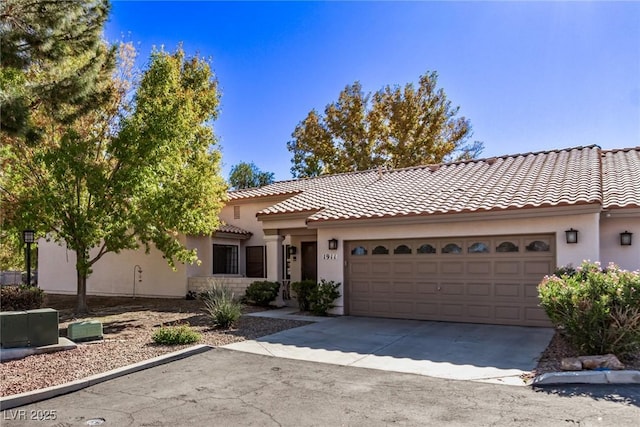 view of front of home with concrete driveway, a tile roof, an attached garage, and stucco siding