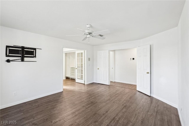 spare room with visible vents, dark wood finished floors, a ceiling fan, and baseboards