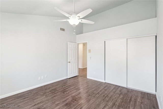 unfurnished bedroom with a closet, visible vents, ceiling fan, wood finished floors, and baseboards