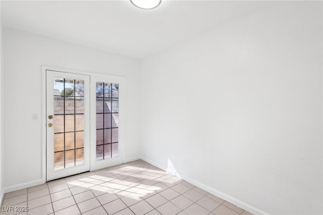 spare room with light tile patterned floors and baseboards