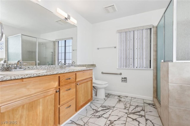 bathroom featuring marble finish floor, a sink, a shower stall, and toilet