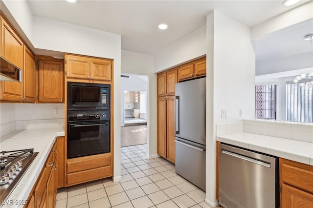 kitchen with recessed lighting, brown cabinets, black appliances, and light tile patterned floors