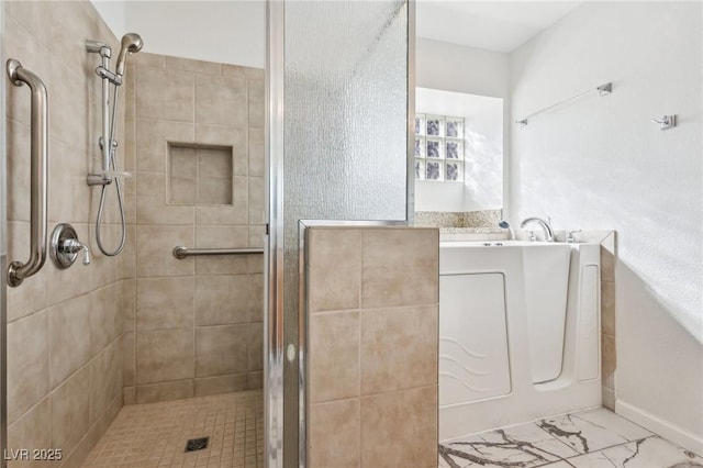 full bathroom featuring marble finish floor and a shower stall