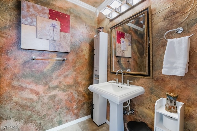 half bathroom featuring ornamental molding, baseboards, a sink, and toilet