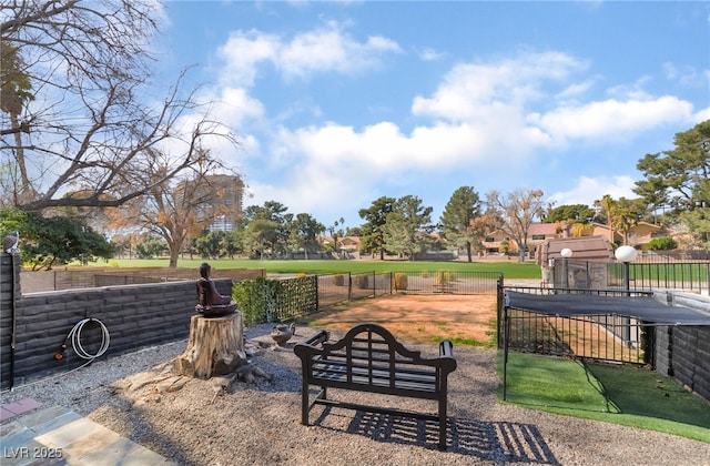 view of home's community with a trampoline and fence