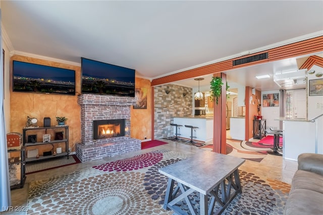 living area featuring ornamental molding, a brick fireplace, and visible vents