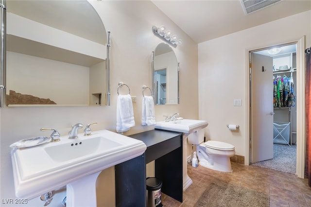 full bathroom featuring toilet, a sink, visible vents, and tile patterned floors